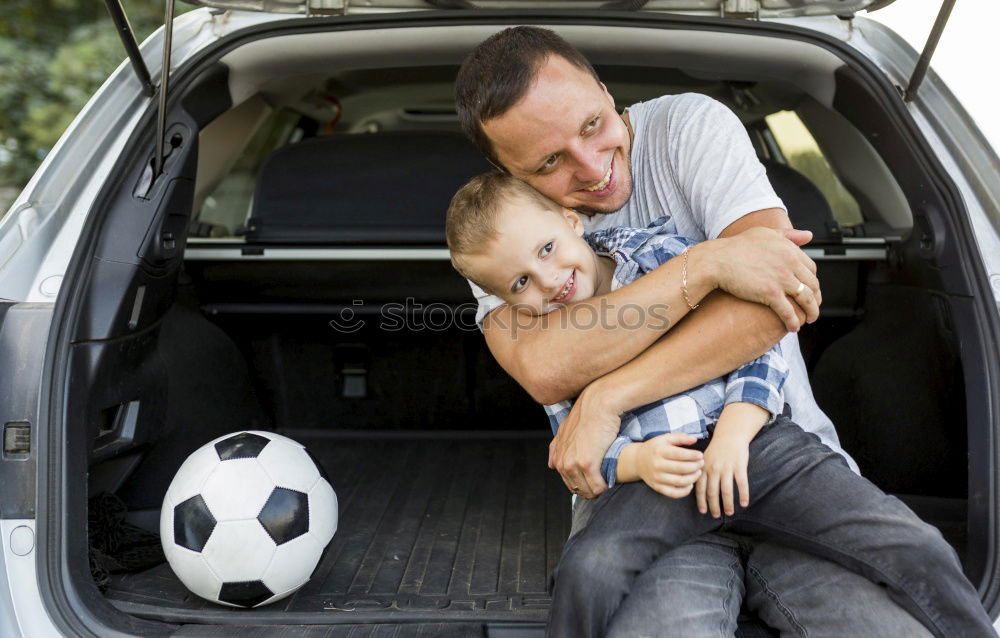 Happy father and son getting ready for road trip on a sunny day.