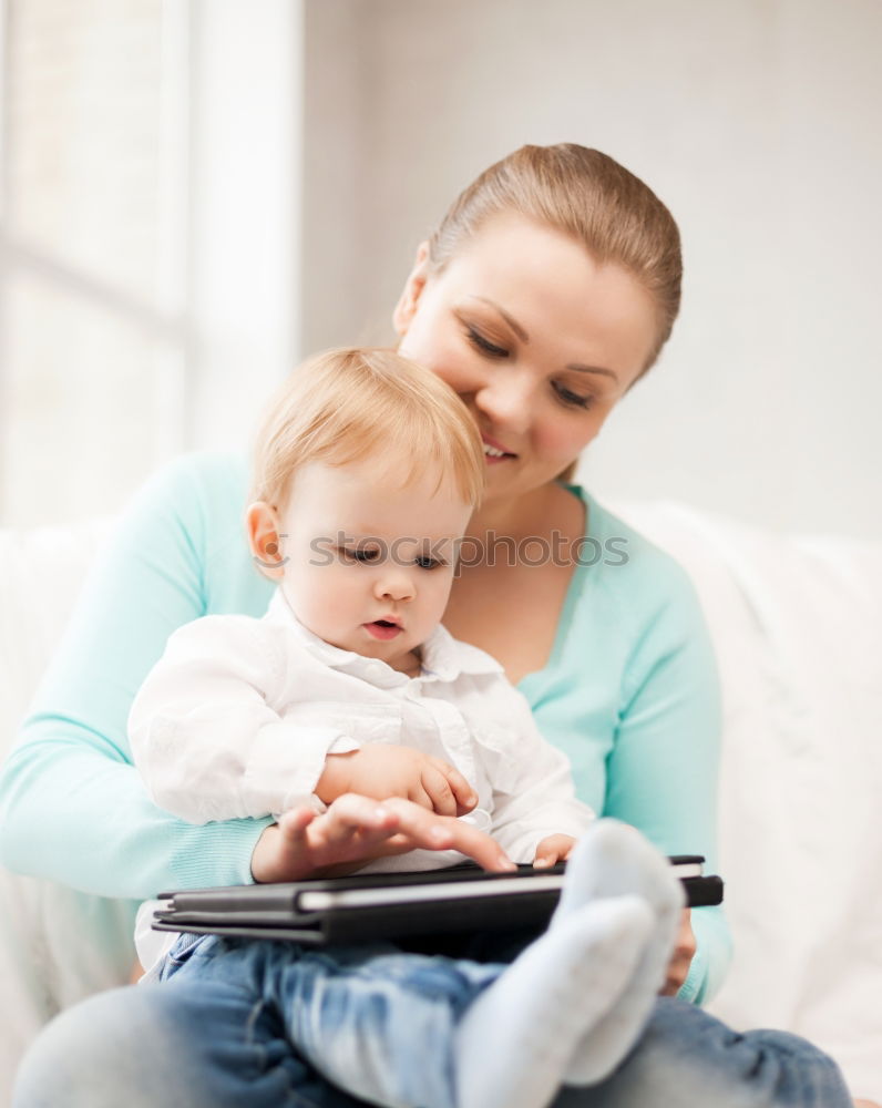 Similar – Mom reading a book her little daughter