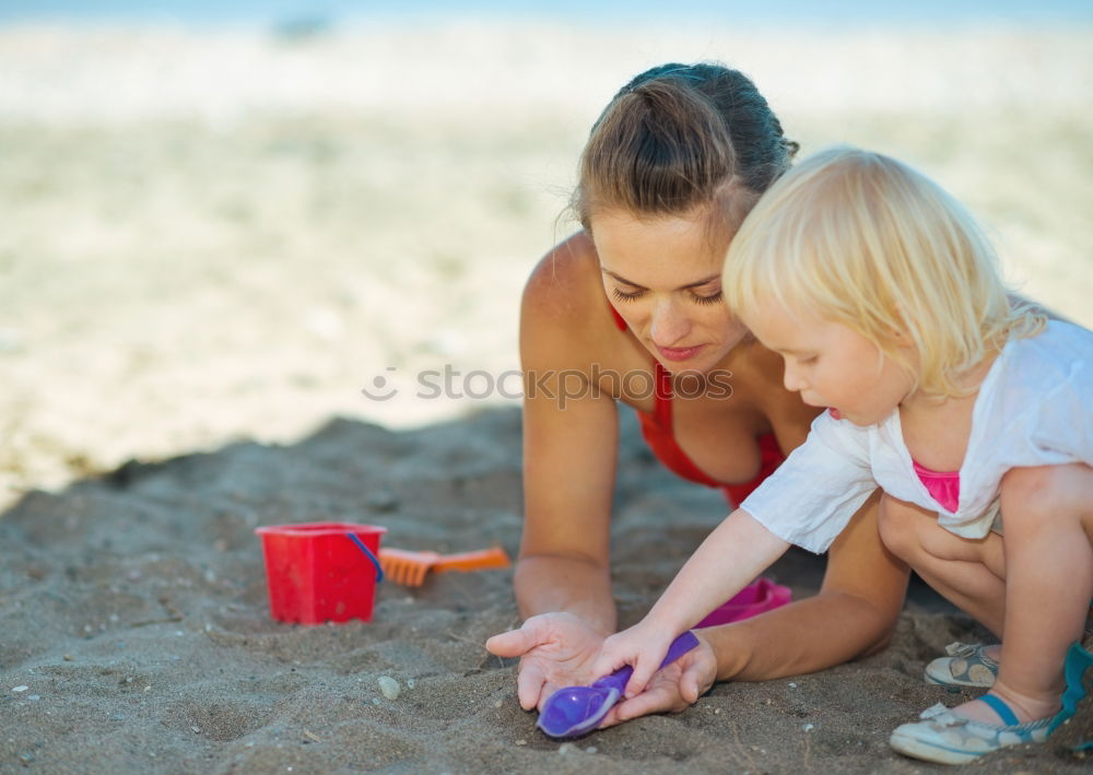 Similar – Image, Stock Photo Mother and toddler son playing with toys at beach