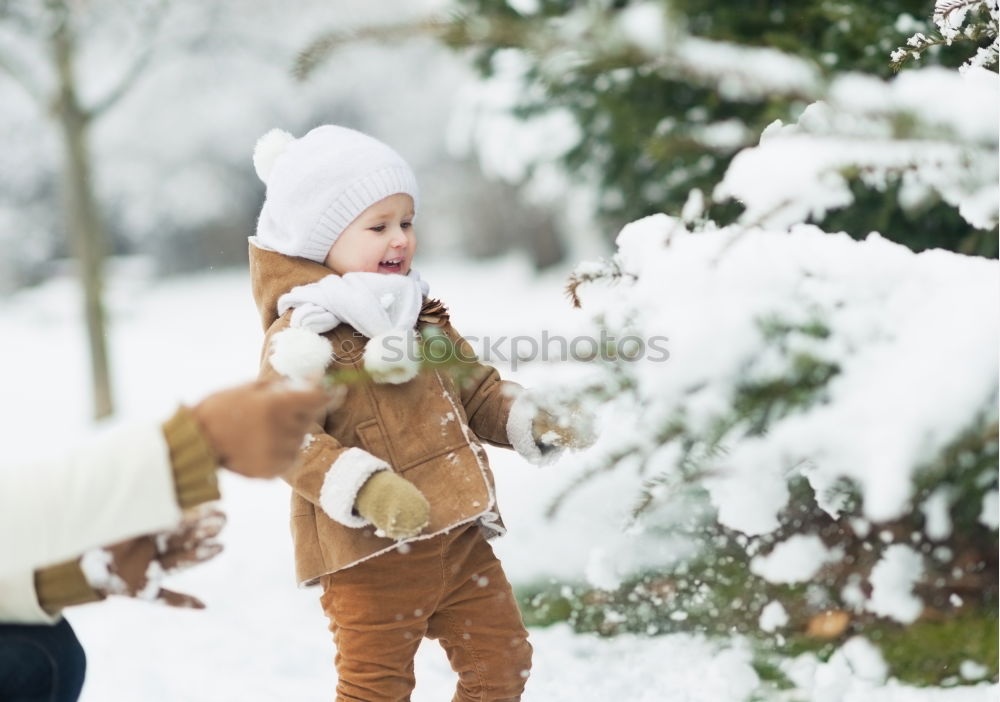 Similar – Image, Stock Photo Mother is playing with her little daughter outdoors on wintery day. Woman is throwing snow on her child. Family spending time together enjoying wintertime. Woman is wearing red coat and wool cap, toddler is wearing dark blue snowsuit