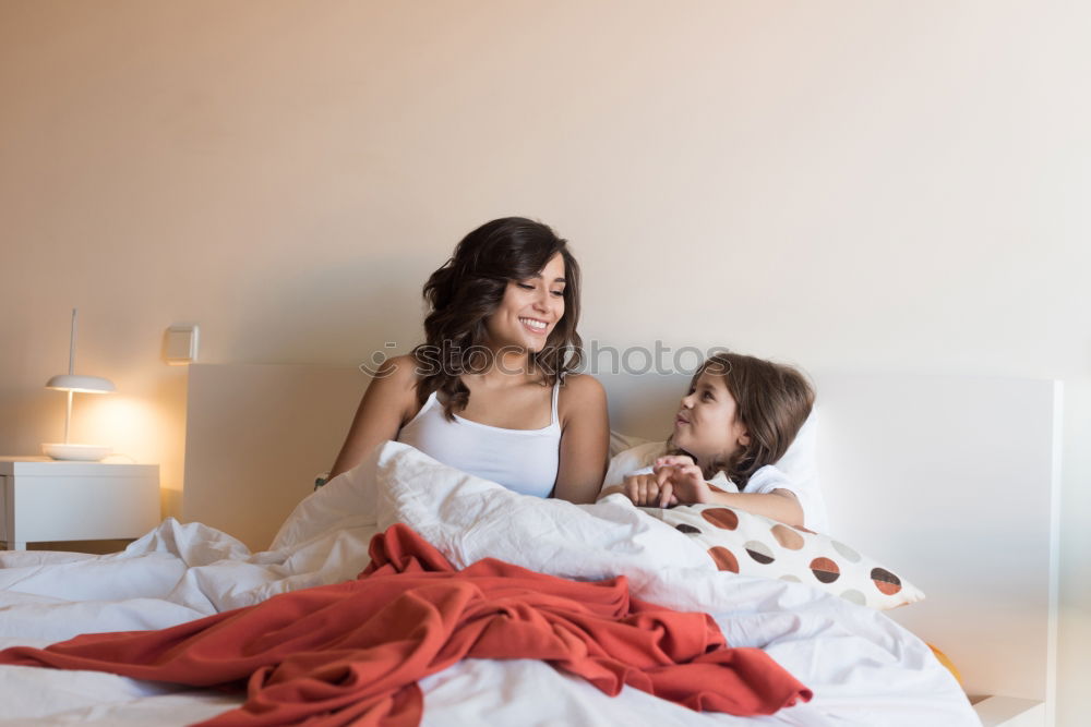 Similar – Girl and boy reading book sitting on bed