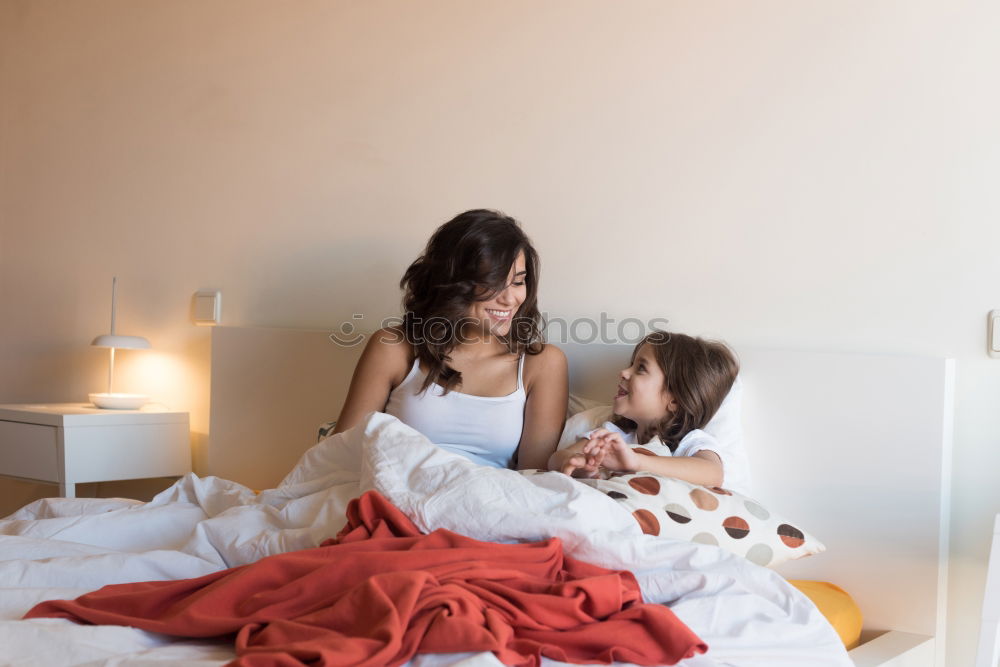 Similar – Girl and boy reading book sitting on bed