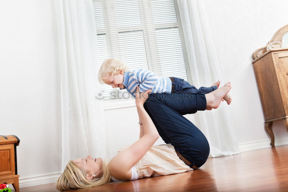 Similar – Image, Stock Photo A baby girl studies something on haunches, while her older brother watches her from upstairs sitting on the steps