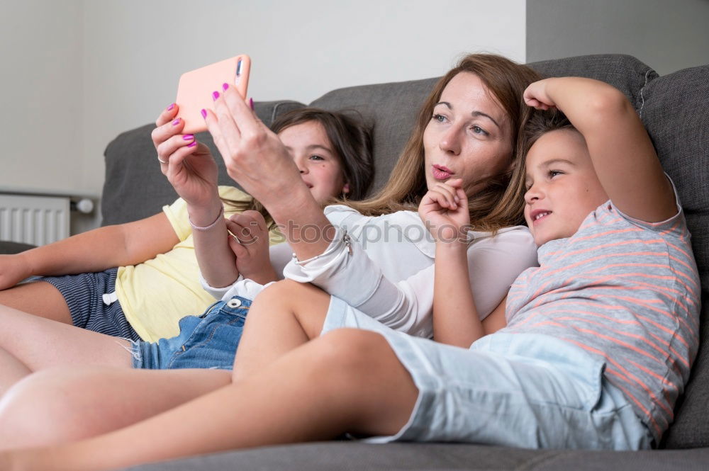 Image, Stock Photo Young women using mobile phones watching music clip, texting, messaging. Teenagers using the smartphones, sitting on sofa at home. Using technology devices. Girls wearing summer clothing