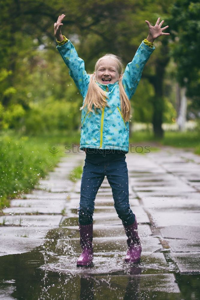 Similar – Image, Stock Photo Boy in a raincoat and rain boots running and playing along a path full of puddles