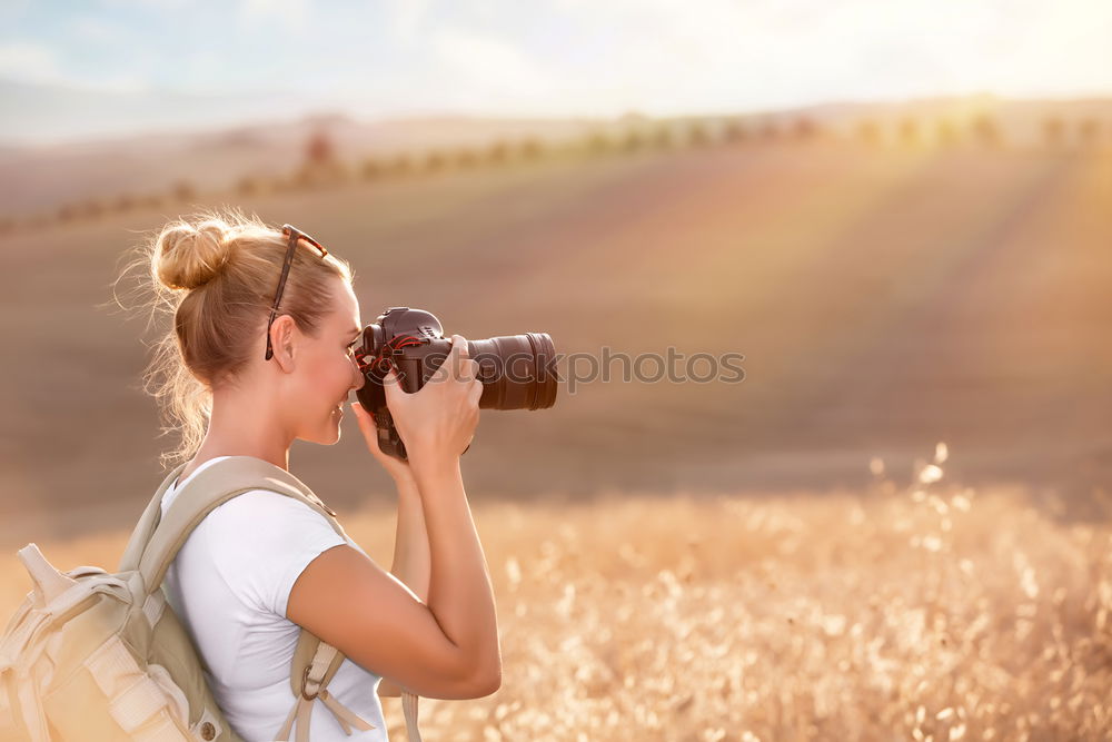 Similar – Smiling young woman using a camera to take photo at the park.