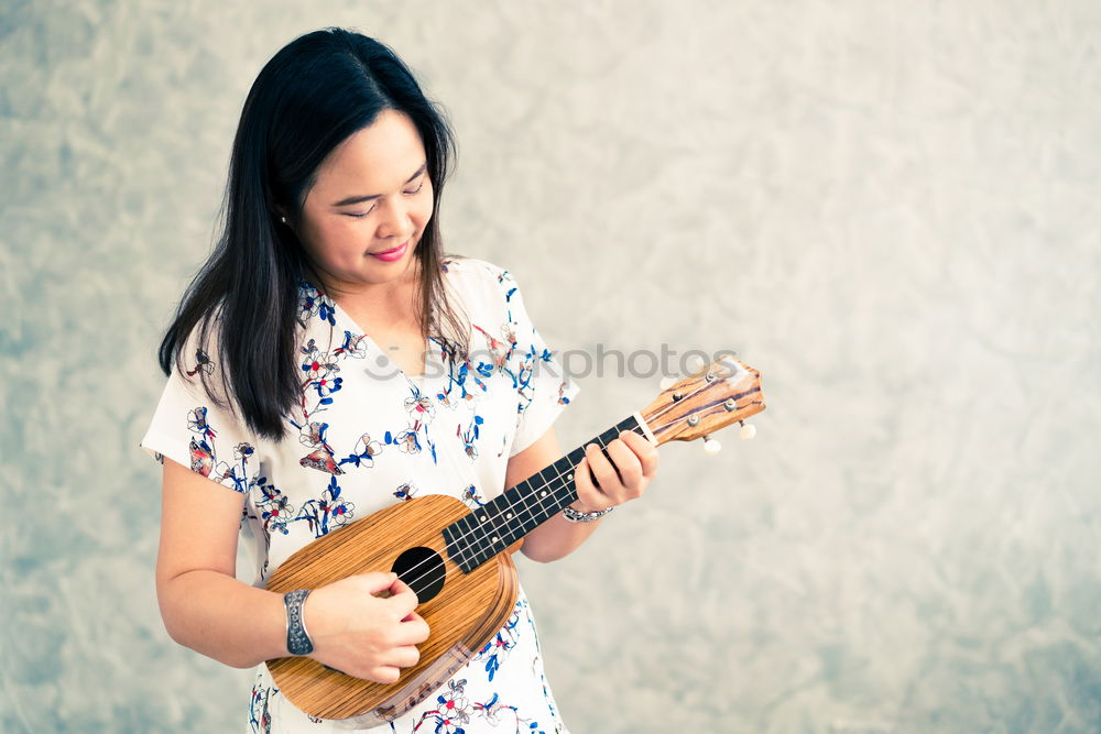 Similar – Mädchen spielt Ukulele im Gartenstuhl