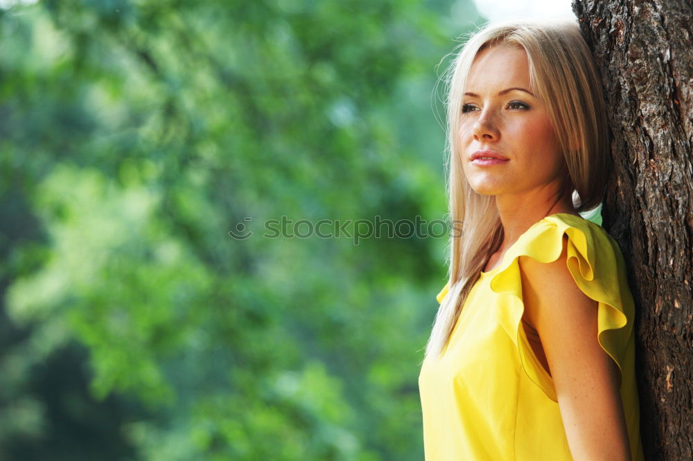 Similar – sad young woman leaning against tree