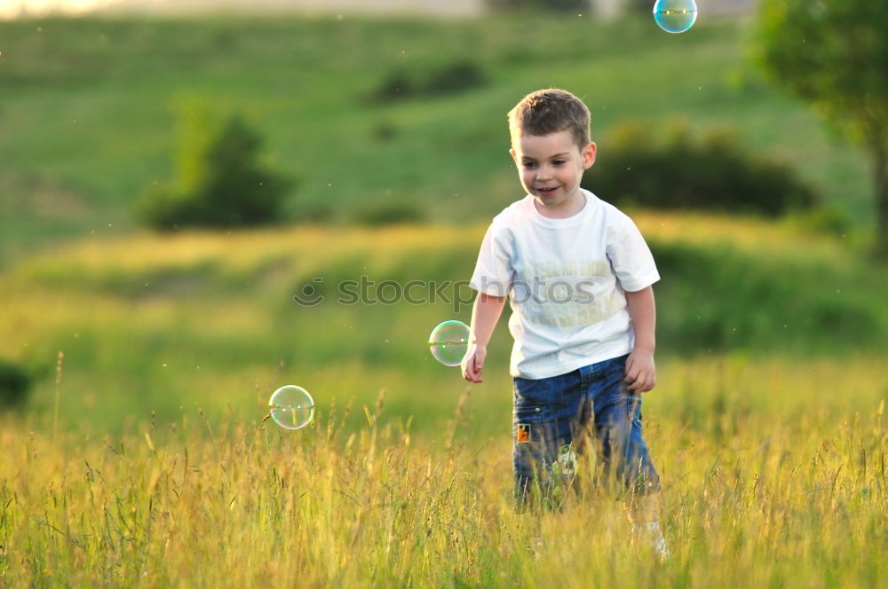 Similar – Image, Stock Photo Happy boy playing with soap bubbles in the park