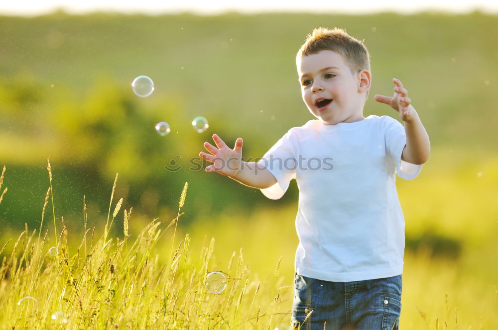 Similar – Image, Stock Photo Happy boy playing with soap bubbles in the park