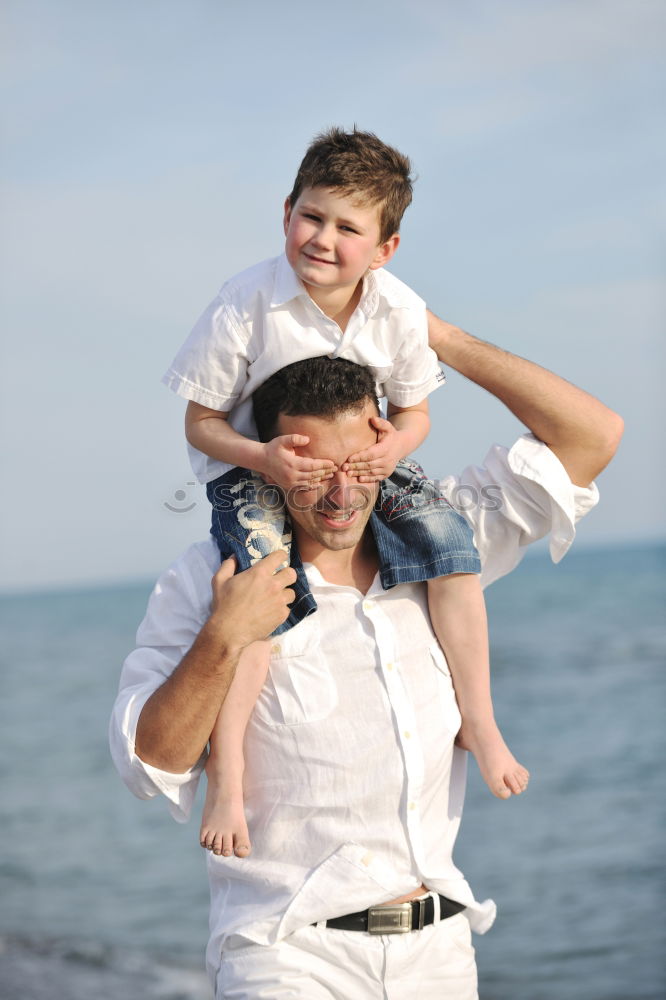 Similar – Image, Stock Photo Smiling father with his young son at the beach crouching down on the sand with a smile as the boy stands alongside him