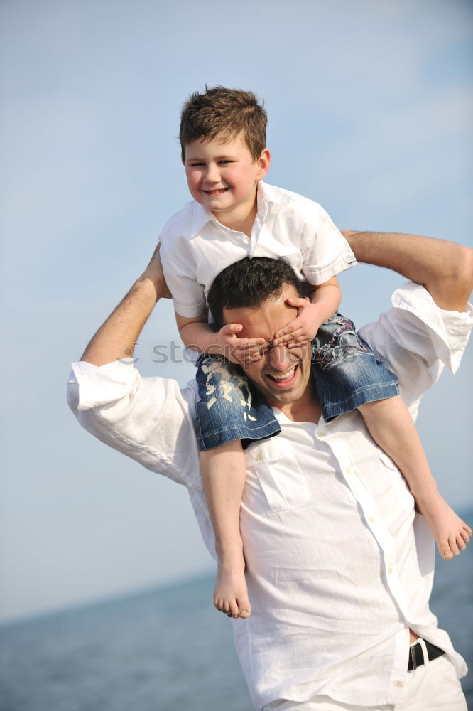 Similar – Image, Stock Photo Smiling father with his young son at the beach crouching down on the sand with a smile as the boy stands alongside him