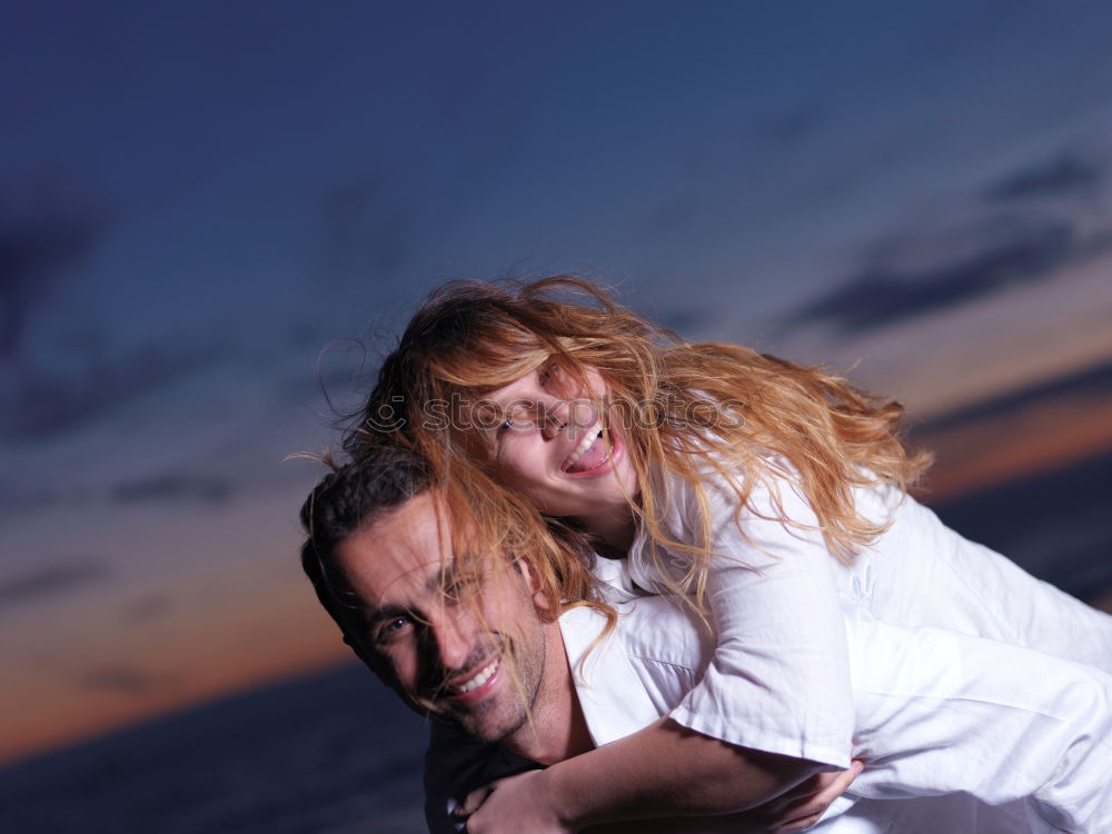 Similar – Bearded man carrying her girlfriend in a piggyback way outdoors at sunset.