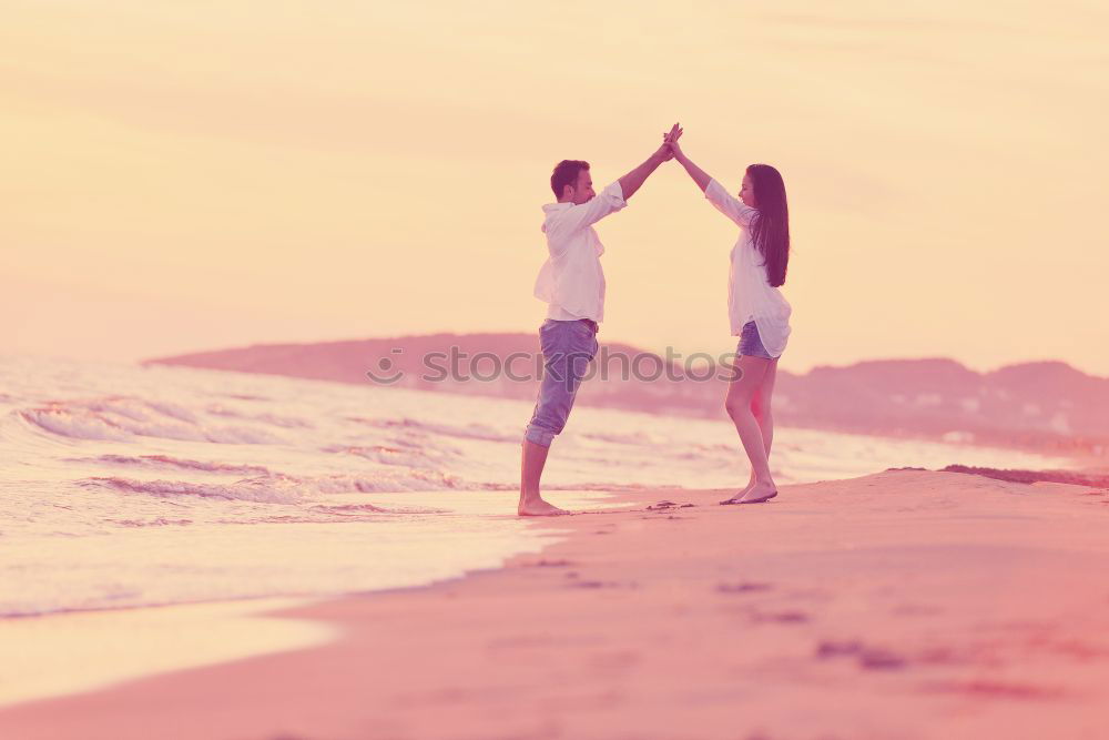 Father and son playing on the beach at the sunset time. Concept of friendly family.