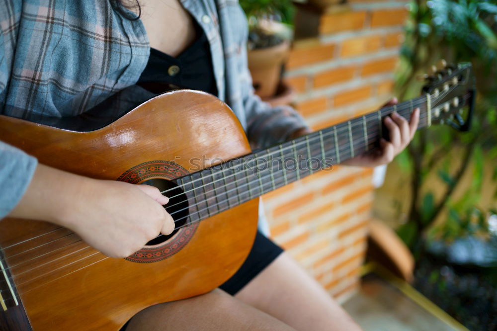 Similar – Mädchen spielt Ukulele im Gartenstuhl