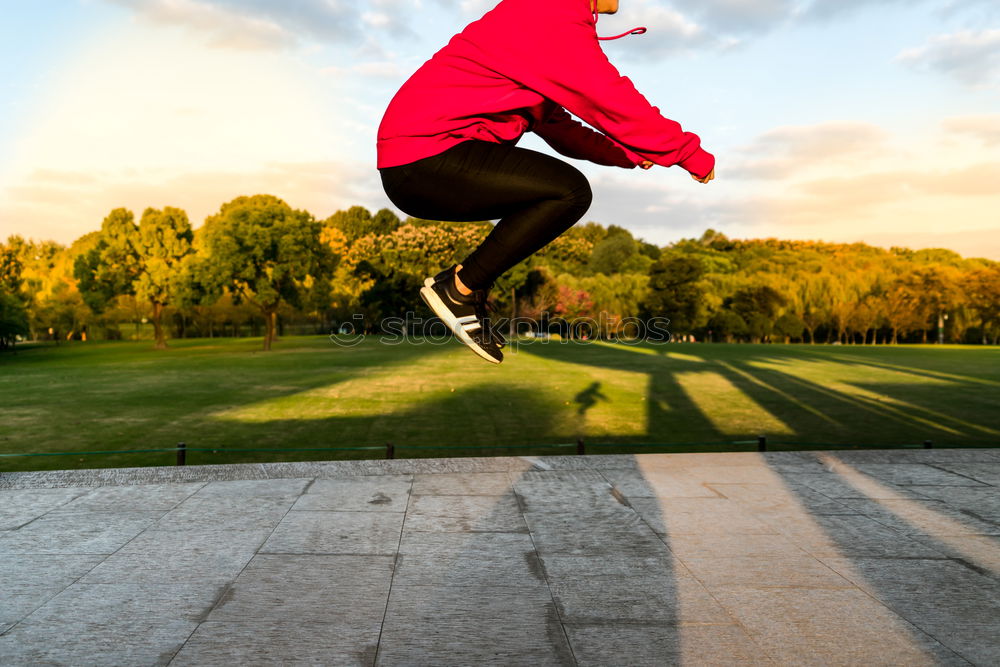 Similar – Woman jumping barefoot over blue rubber hills