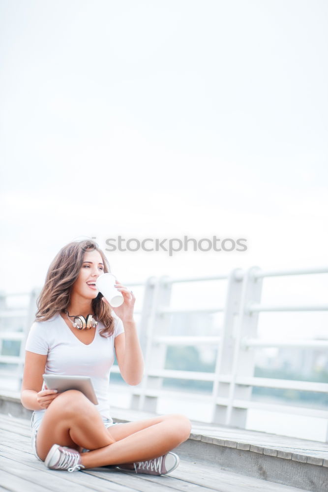 Similar – Brunette woman leaning on handrail at river