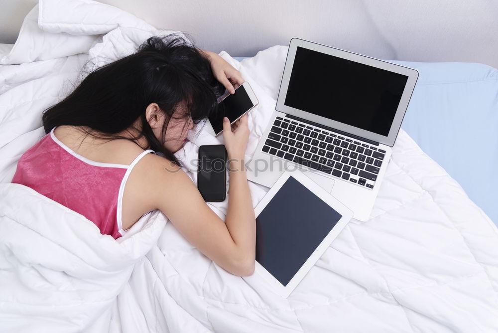 Similar – Young girl looking at mobile phone while sitting on bed