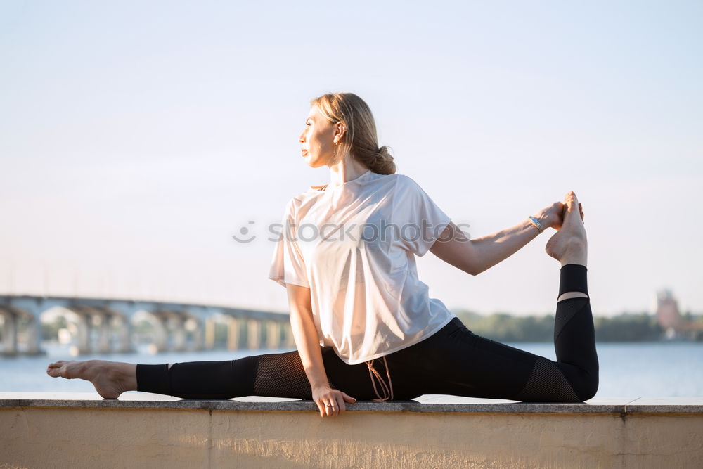 African American sportive woman sitting in lotus pose and stretching hands up