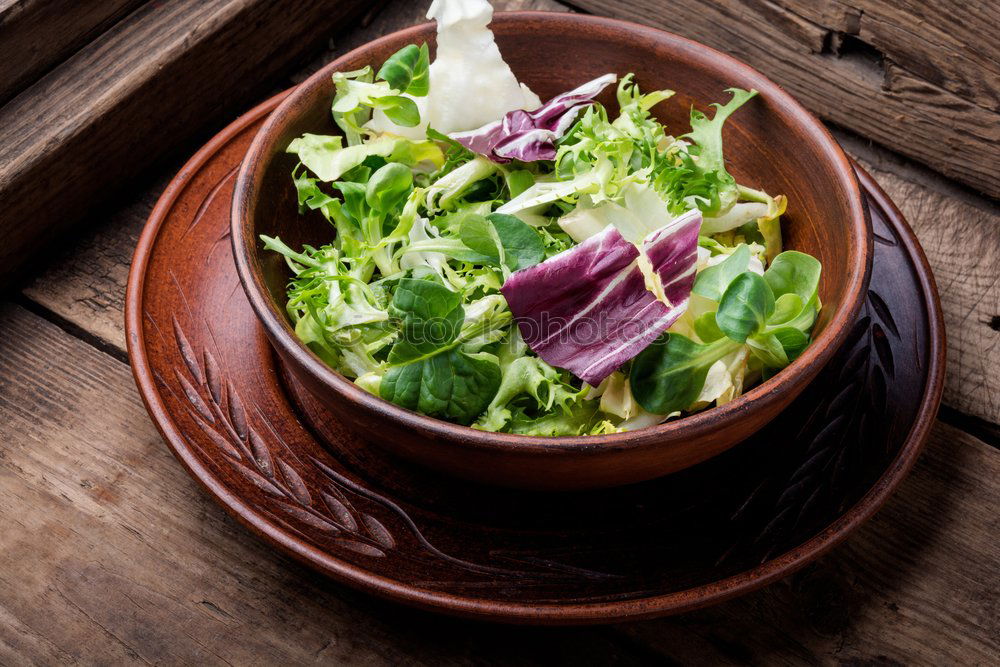 Similar – Healthy green salad with dressing on dark background