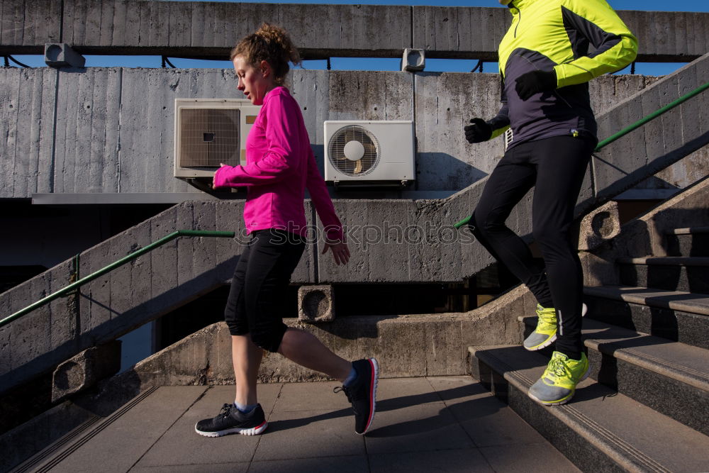 Active young couple jogging in an urban street