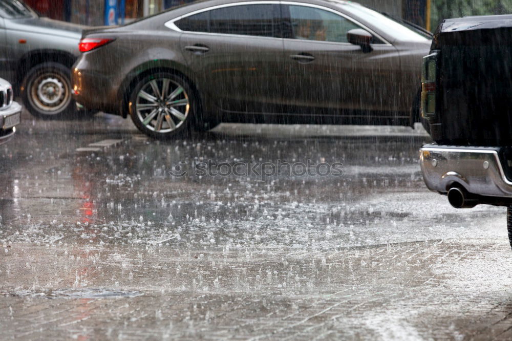 Similar – Whoosh!!! There thunders the dark car full through a deep puddle. A huge shower of water drenches the pedestrian with a colorful umbrella and red rubber boots.