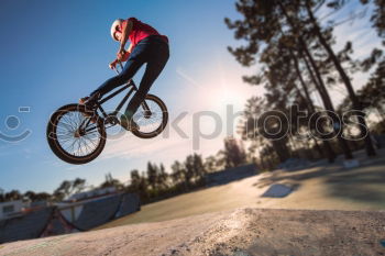 Similar – Young cyclist on the edge of a rock ready to jump