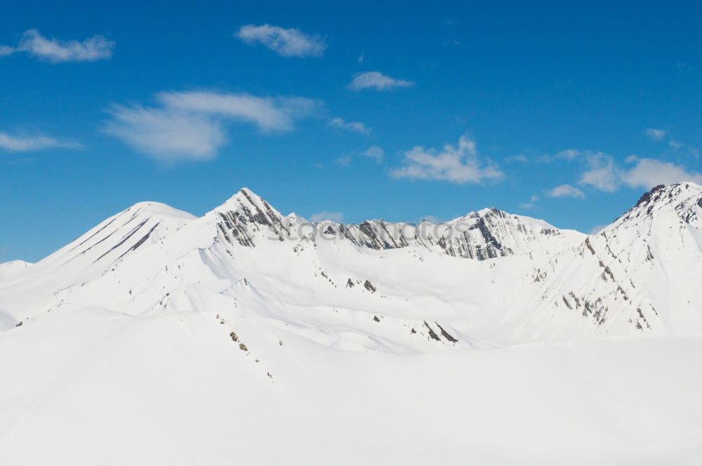 Similar – Snowy blue mountains in clouds at sunset