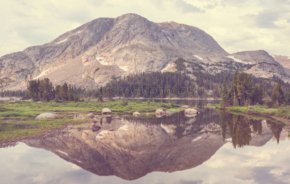 Similar – Wonderful lake between hills in snow and cloudy sky