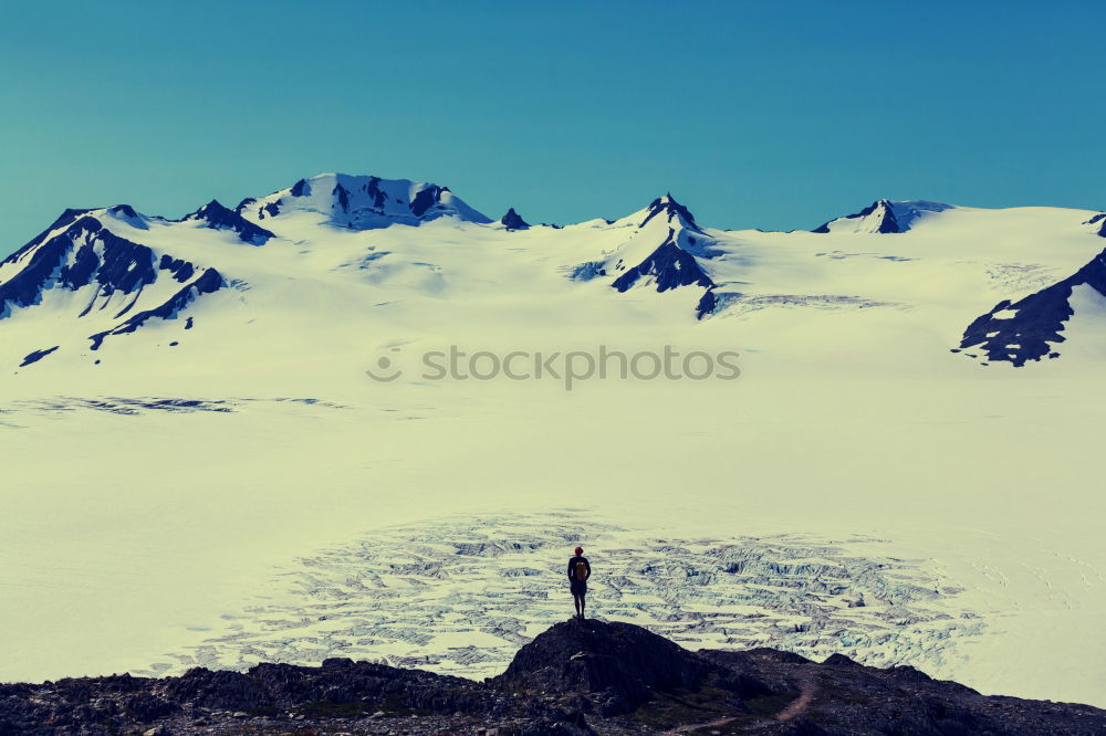 Similar – Mountaineer with dog climbing on mountain top