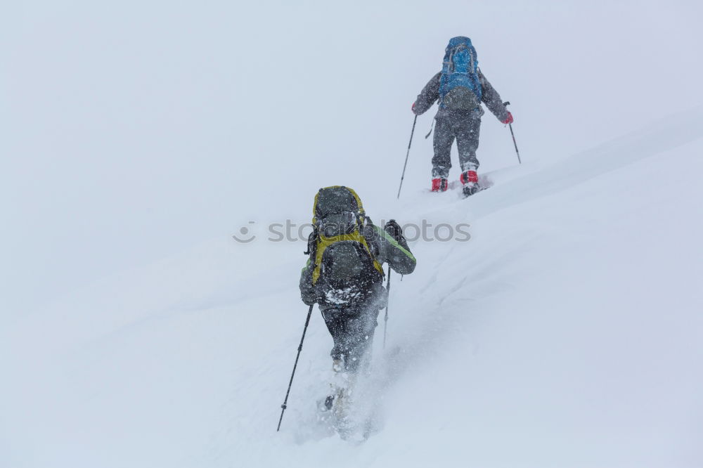 Similar – Female climber in the storm during an extreme winter climb