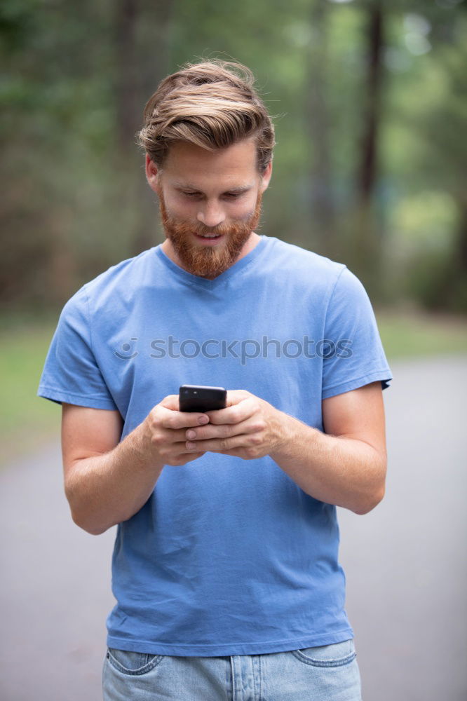 Similar – Image, Stock Photo Young smiling man looking at his smartphone in the street