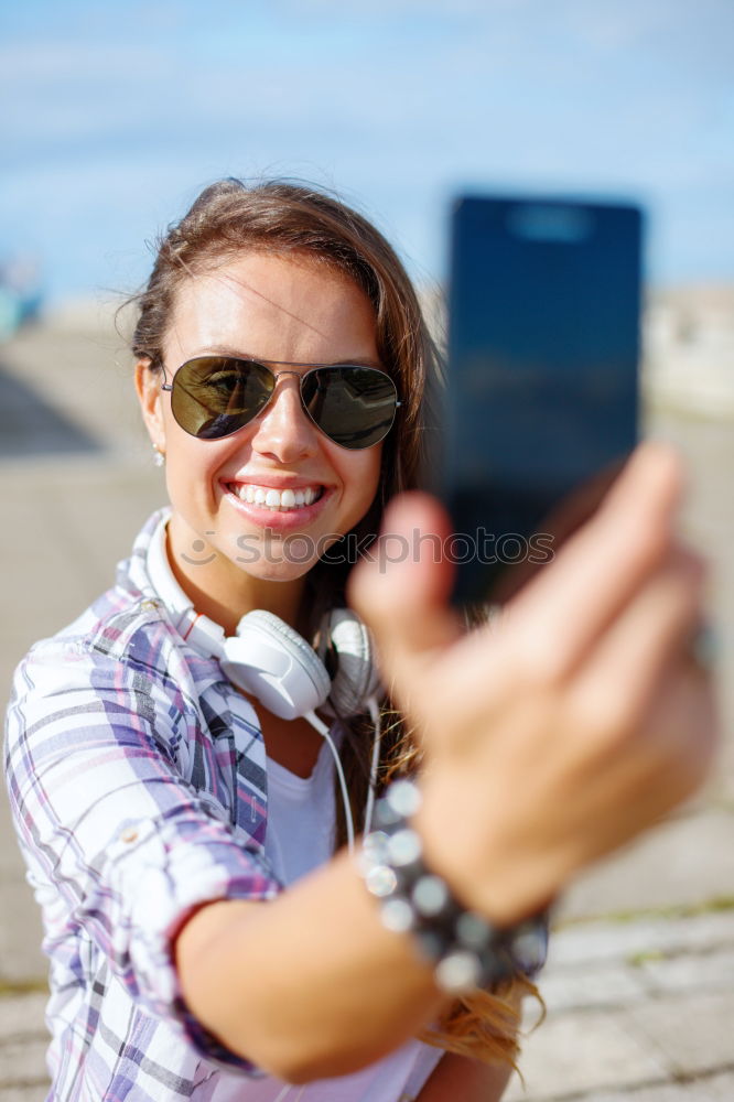 Similar – Young happy woman with green jacket taking selfie with her smartphone on the beach at sunset