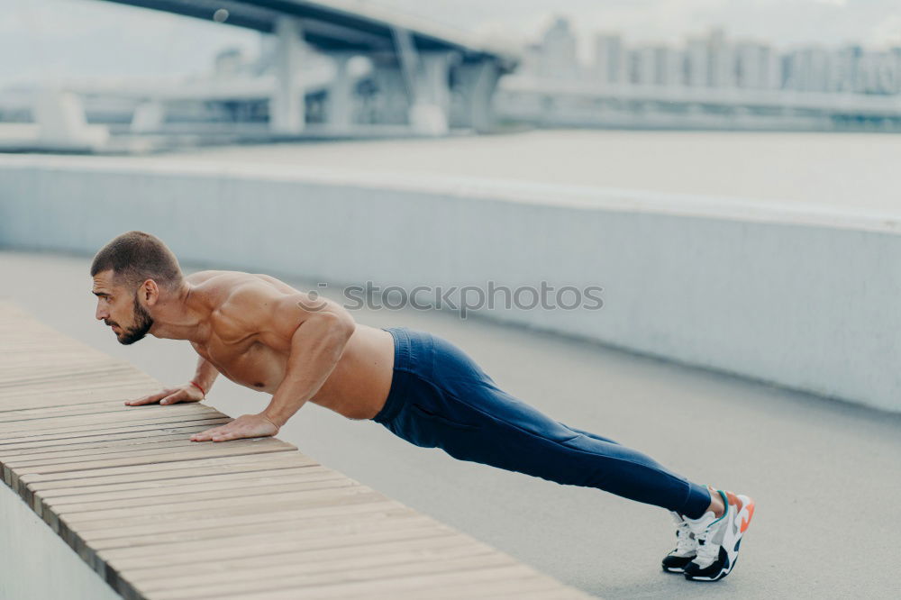 Similar – Seitenschuss eines muskulösen Mannes macht umgekehrte Push-up-Übung, trainiert die Arme, hält perfekten Körper und gute körperliche Form, trainiert aktiv im Freien, trägt Sporthosen und Turnschuhe, posiert auf der Brücke