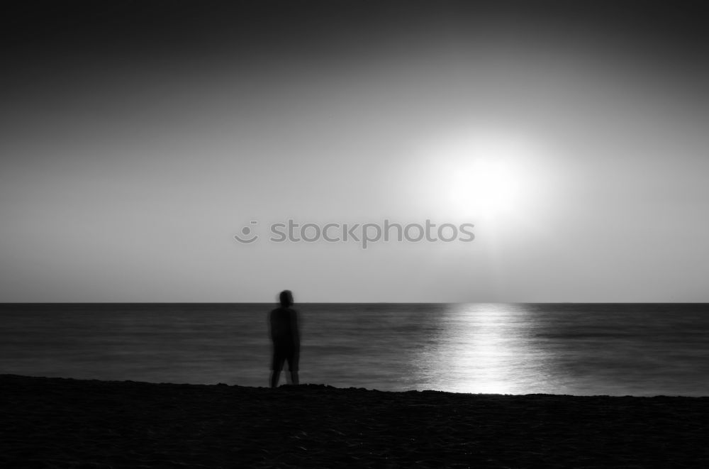 Similar – Photographer silhouetted in the sunset by the sea