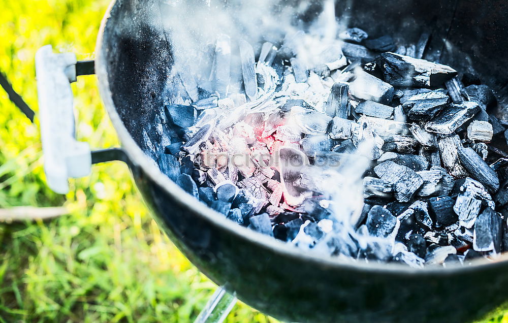 Hot coals with smoke in grill