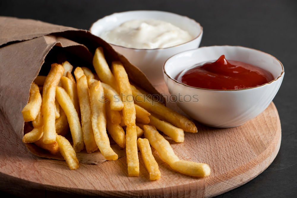 Similar – Foto Bild Portion Pommes mit Mayonnaise in einem Pappschälchen und einer Holzgabel auf einem Holztisch