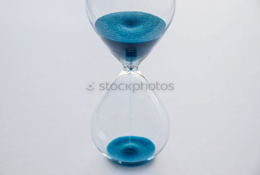 Hourglass with black sand running out