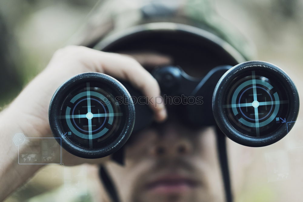 Similar – Bearded man dressed in blue t-shirt with binoculars posing against black background