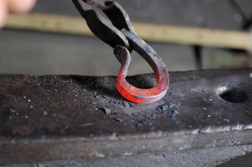 Similar – Blacksmith forges iron on anvil