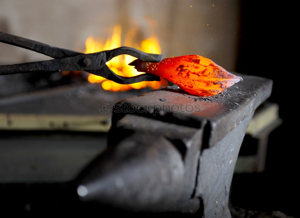 Similar – Blacksmith forges iron on anvil