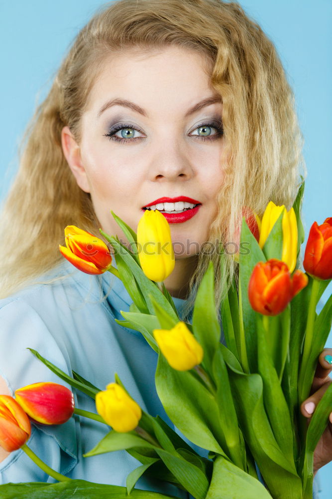 Similar – Redhead woman smelling a flower in a park