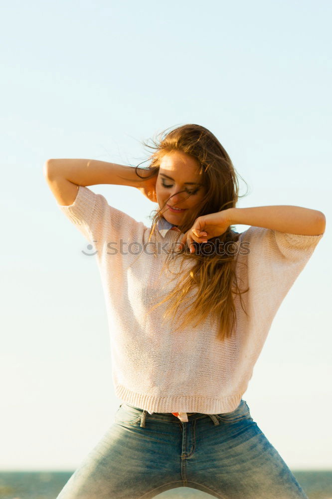 Similar – Cute woman touching her hair while the wind moves it.