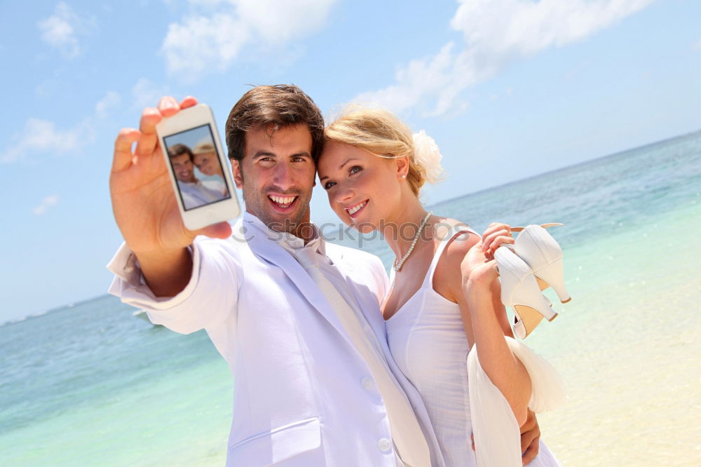 Similar – Happy young man and woman in fashionable sunglasses taking cellphone selfie on background of defocused blue sea. Vacation photos