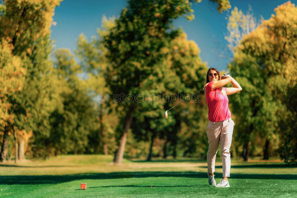 Female golfer practicing on a driving range