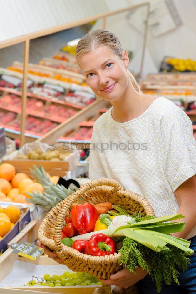 Similar – Image, Stock Photo Young woman shopping for fresh tomatoes at an open-air stall choosing items from a row of wooden boxes