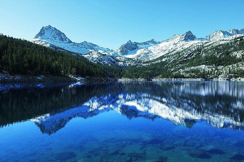 Similar – snowy mountain lake with mountains and blue sky