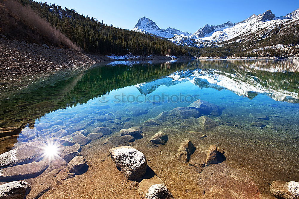 Similar – snowy mountain lake with mountains and blue sky