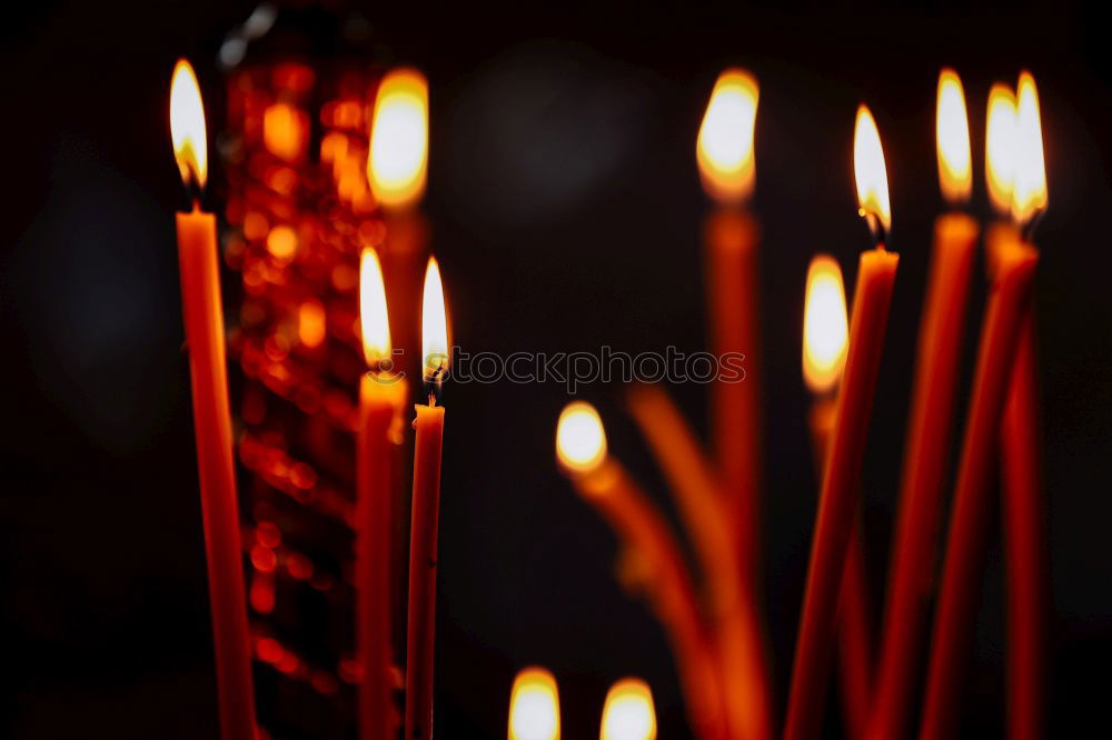 Similar – Image, Stock Photo many church candles with varying degrees of burn stuck in the sand in the dark. selective focus. dripping wax from one candle.