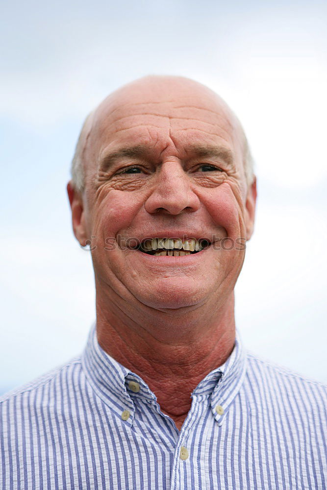 Similar – Portrait of a senior citizen with short grey hair and three-day beard in front of a blue-grey sky